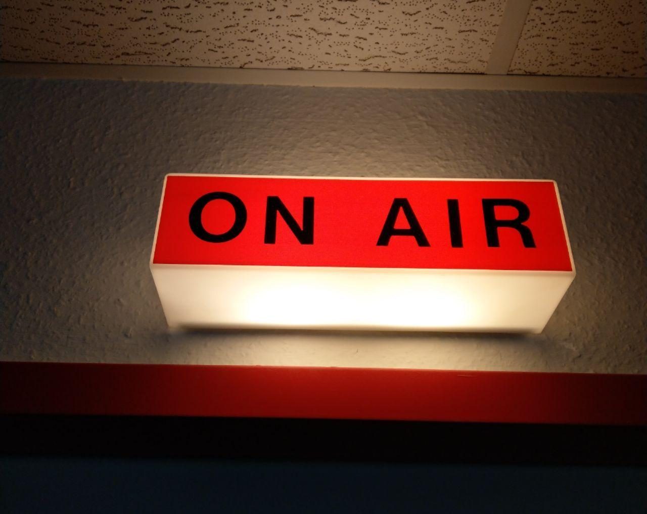 Das On-Air-Schild über der Studiotür leuchtet rot auf.