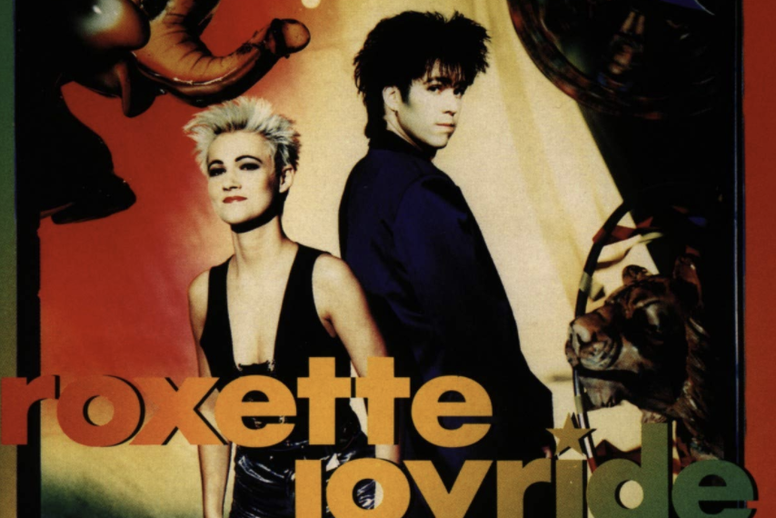 Auf dem Albumcover "Joyride" von Roxette sind Marie Fredriksson und Per Gessle zu sehen. Der Hintergrund ist sehr bunt und es sind eine Lichterkette, ein Elefant und ein Tiger zu sehen.