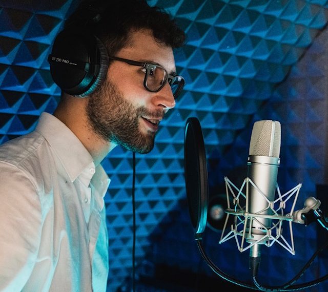 Yves Simon spricht in seinem Homestudio in ein Mikrofon.