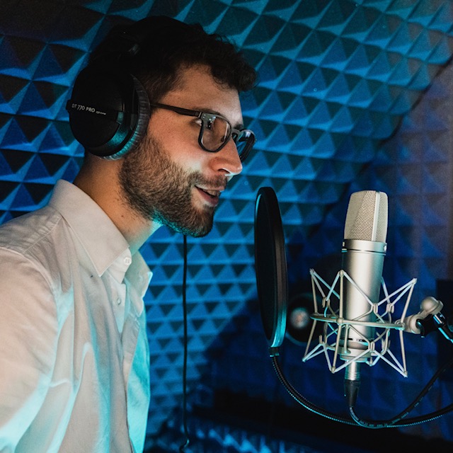 Yves Simon spricht in seinem Homestudio in ein Mikrofon.