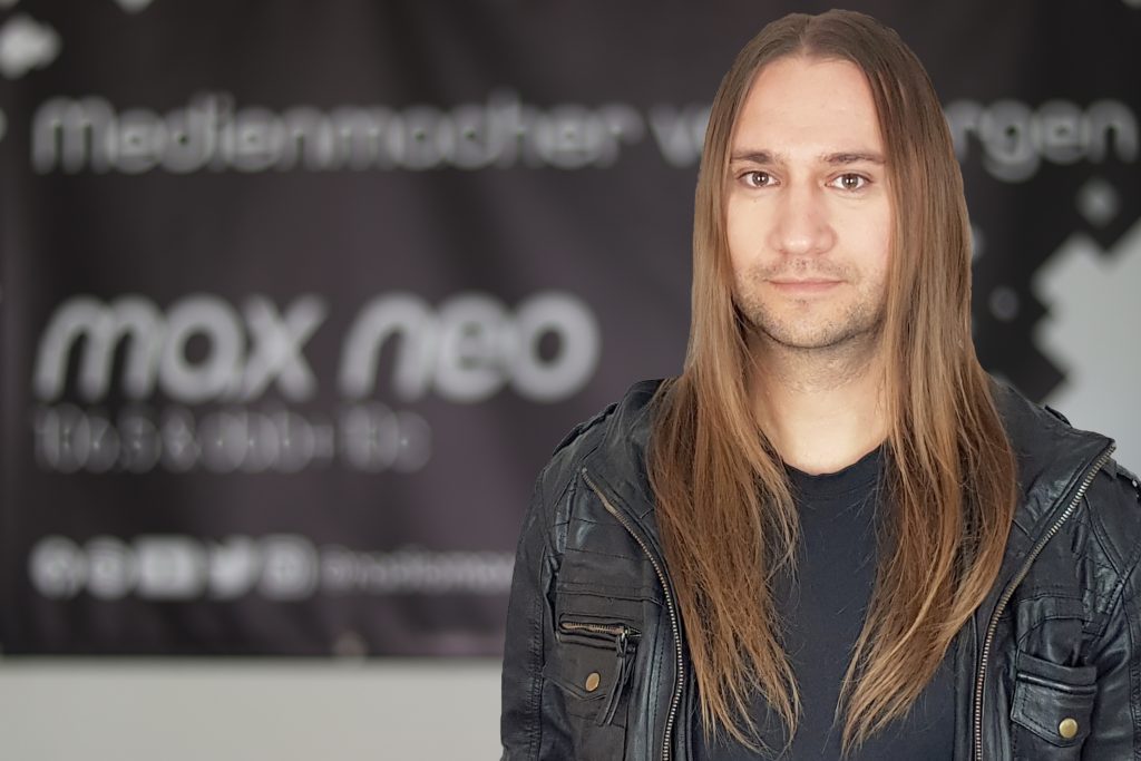 Matthias Engelhardt steht vor dem max neo Banner.