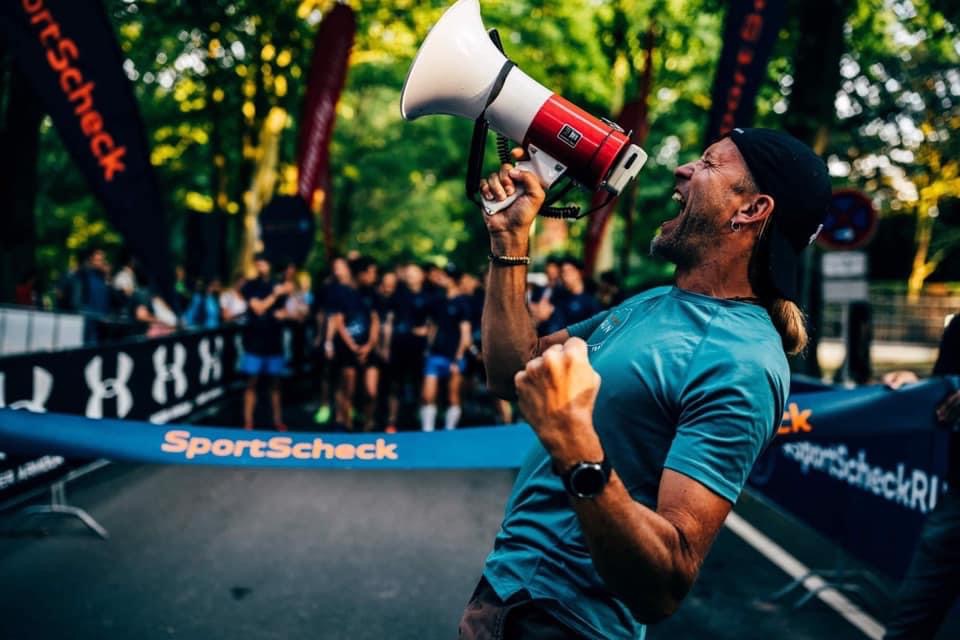 Claudio Großner spricht bei einem Sportevent in ein Megafon.