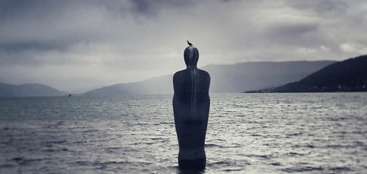 Das Albumcover "Falling From Fame" von tAKiDA zeigt eine Statue im Meer. Auf dem Kopf der Statue sitzt ein Vogel. Im Hintergrund sieht man Berge und graue Wolken am Himmel.