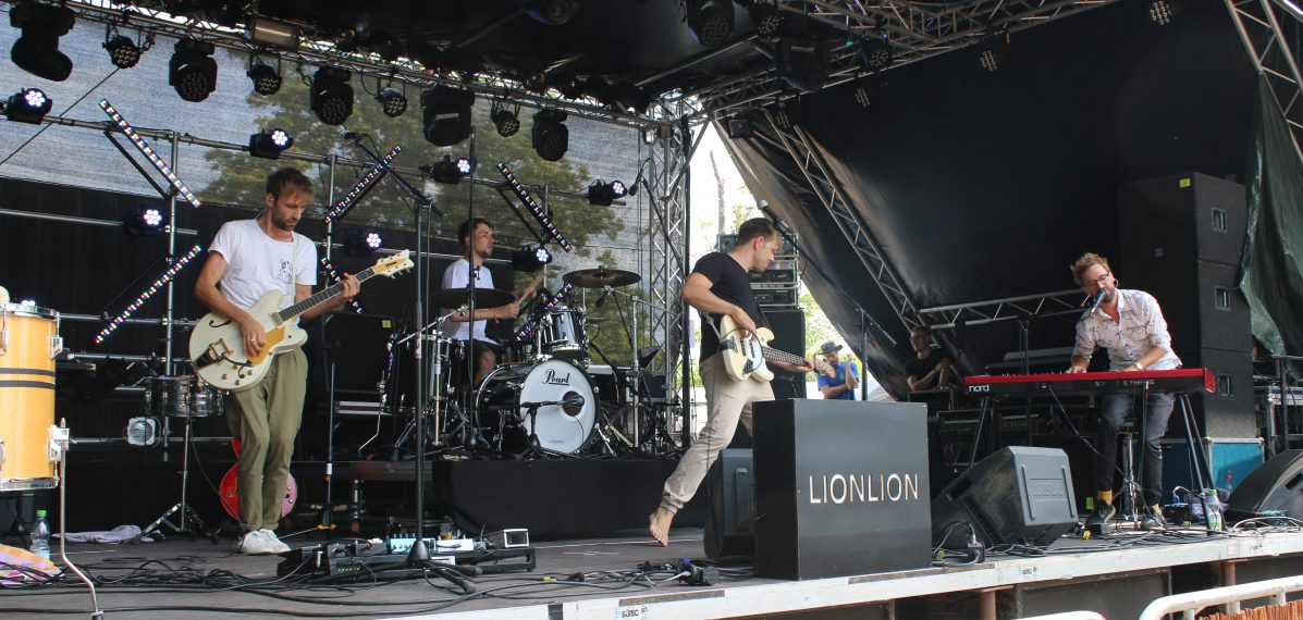 Das Foto zeigt LionLion bei ihrem Auftritt 2018 auf dem Weinturm Open Air in Bad Windsheim. Die vier Jungs spielen gerade einen Song auf der Bühne.