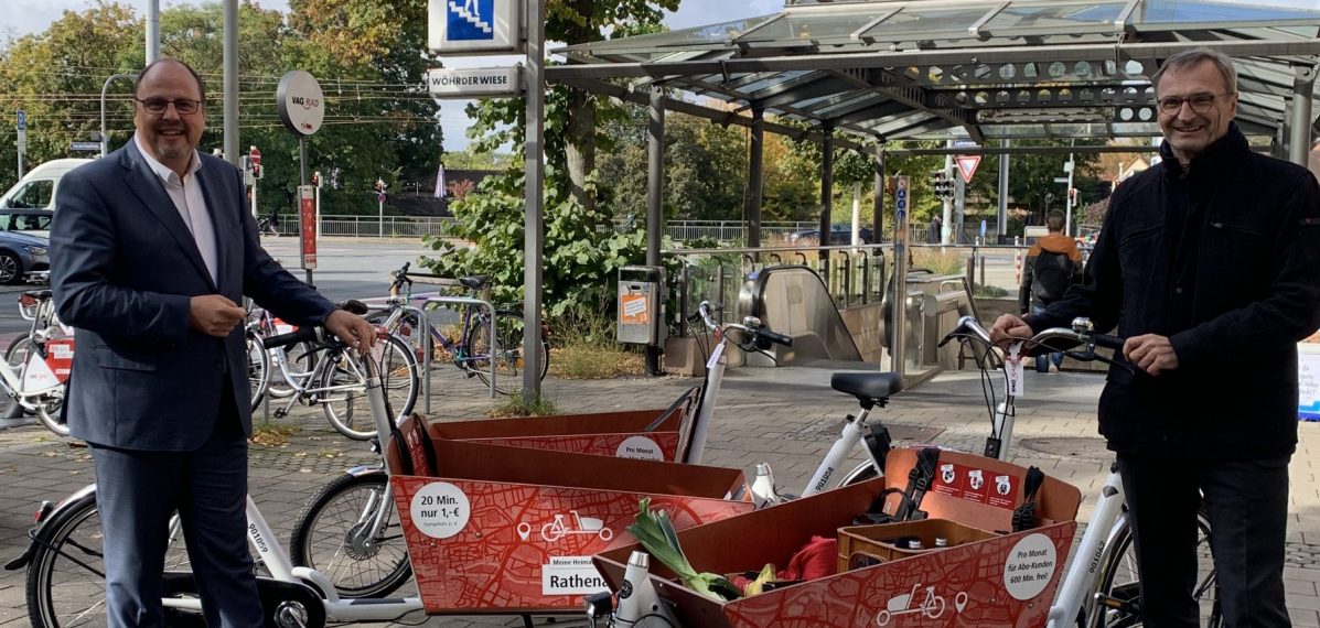 Im Hintergrund ist die U-Bahnstation Wöhrder Wiese zu sehen. Davor stehen Christian Vogel und Josef Hasler. Dazwischen stehen drei Lastenräder der VAG Nürnberg.