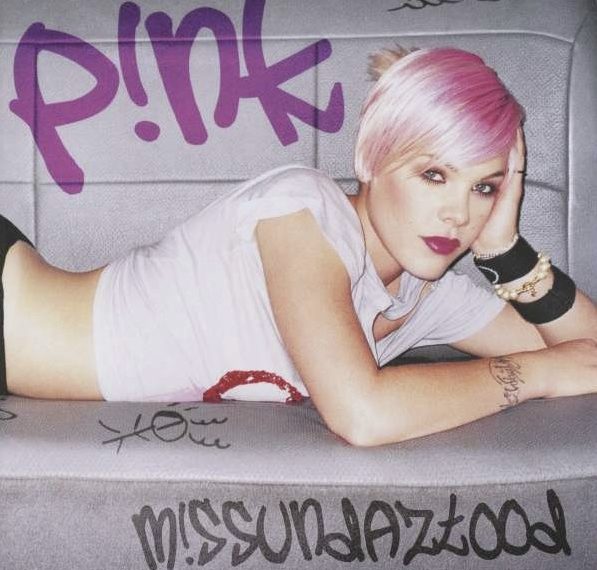 Das Albumcover "M!ssundaztood" von P!nk zeigt die Sängerin mit pinken Haaren und bauchfreiem T-Shirt, wie sie auf einer grauen Couch liegt und sich auf ihrem Ellbogen abstützt. Sie schaut in die Kamera.