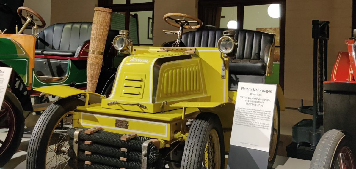 Auf dem Foto sieht man einen gelben Motorwagen aus dem 20. Jahrhundert.