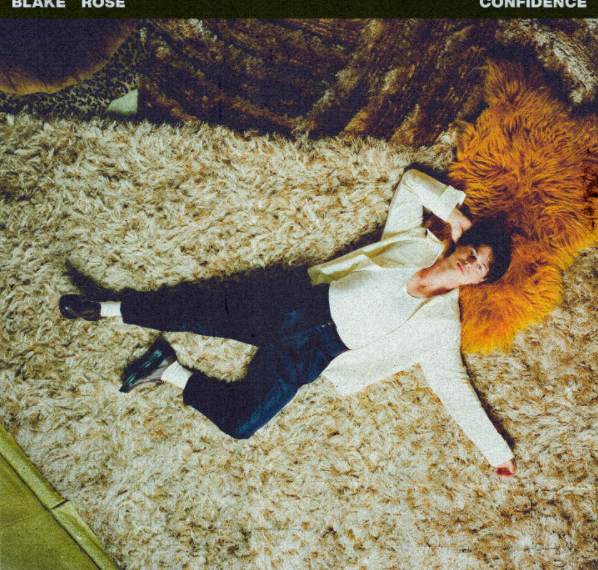Das Cover der Single "Confident" von Blake Rose zeigt den Sänger, wie er am Boden auf einem kuschelige, weißen Teppich liegt. Das Foto ist von oben aus der Vogelperspektive aufgenommen.