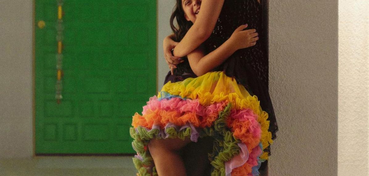 Das Albumcover "Familia" von Camila Cabello zeigt Cabello, wie sie ihre Cousine umarmt. Cabello trägt einen bunten Rock.