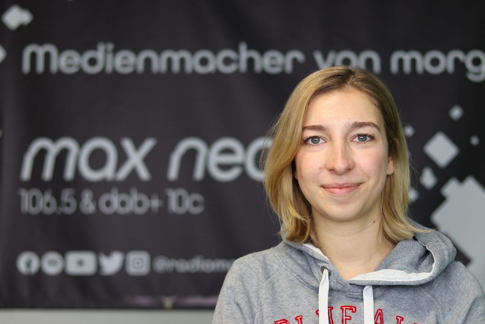 Auf dem Foto ist Celine Pickel im Porträt vor dem max neo Banner zu sehen.