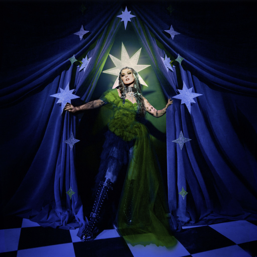 Das Albumcover "Nocturnal" von Mothica zeigt die Sängerin in einem grün-blauen Outfit. Sie steht in der Öffnung eines blauen Theatervorhangs, der mit Sternen beklebt ist.