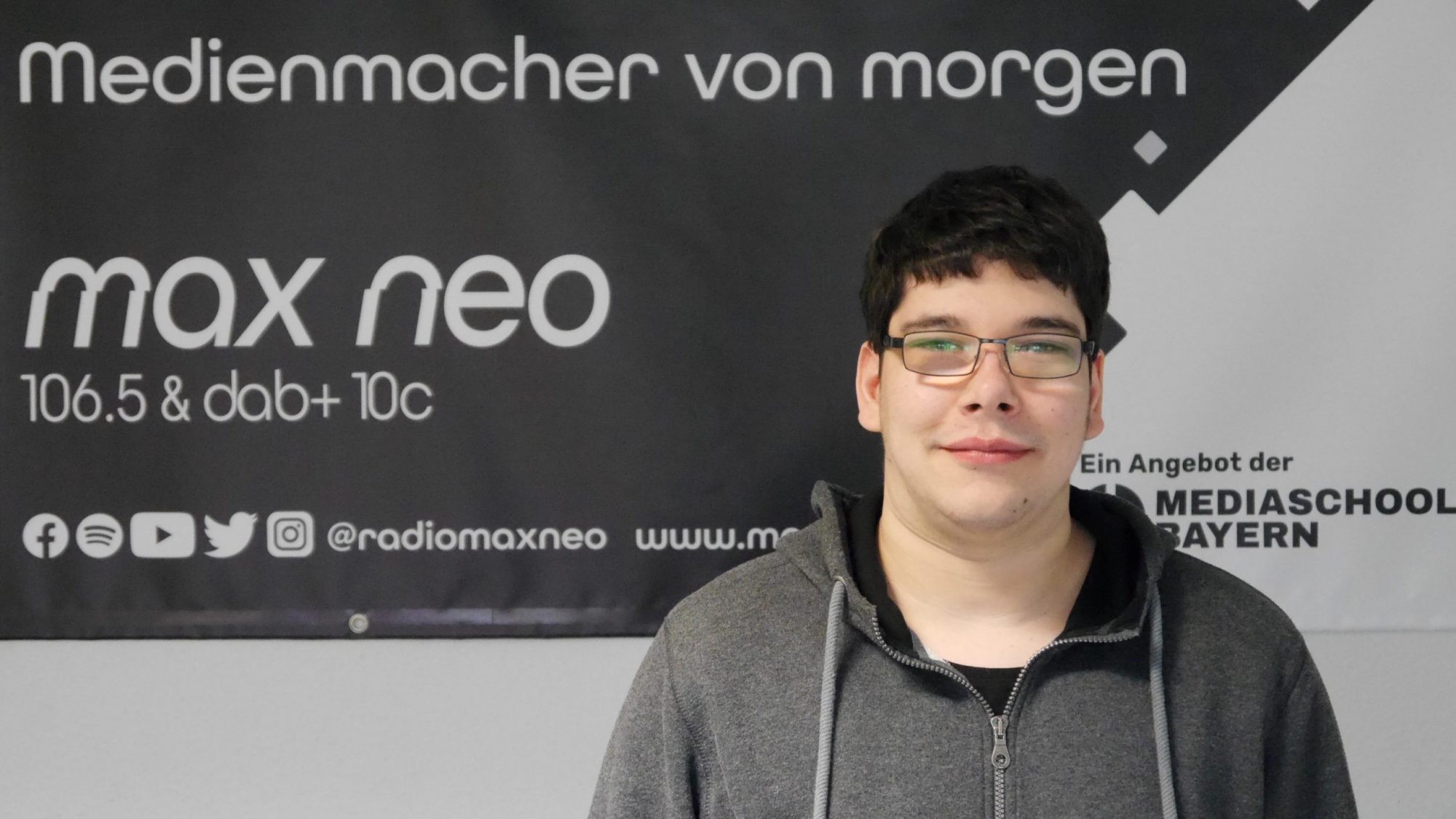 Nils Hermsdörfer steht vor dem max neo Banner und ist im Porträt zu sehen.