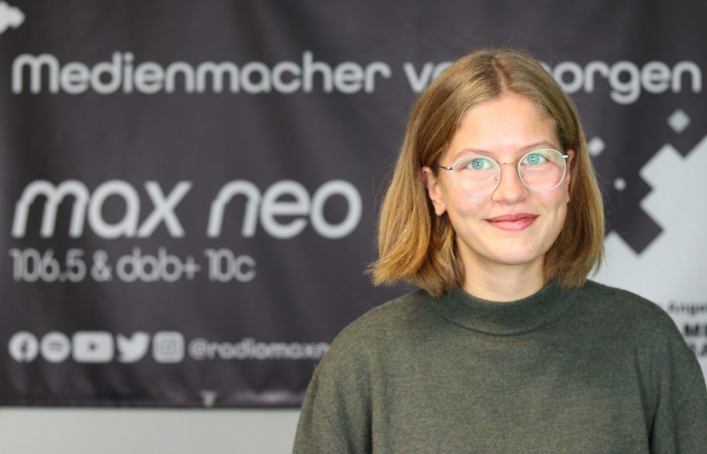 Auf dem Foto ist Lina Paulsen im Porträt vor dem max neo Banner zu sehen.
