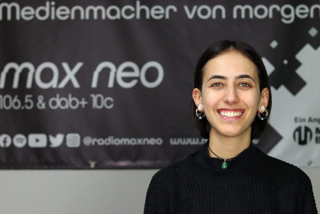 Auf dem Foto ist Melissa Igdi im Porträt vor dem max neo Banner zu sehen.