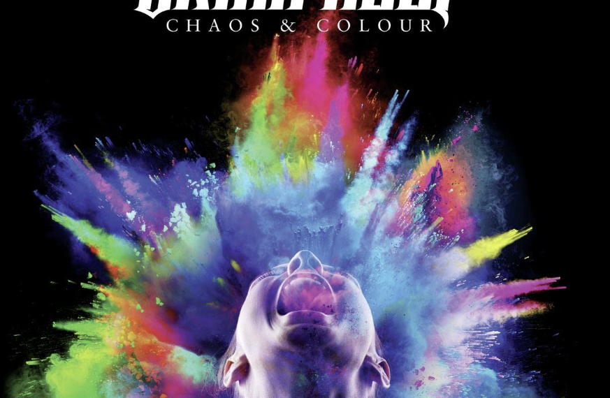 Das Albumcover "Chaos & Colour" von Uriah Heep zeigt einen Menschen, der nach oben schaut und den Mund aufreißt. Um ihn herum sind explodierende Farbpartikel.