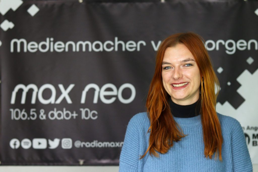 Das Foto zeigt Sophie Rose im Porträt vor dem max neo Banner.