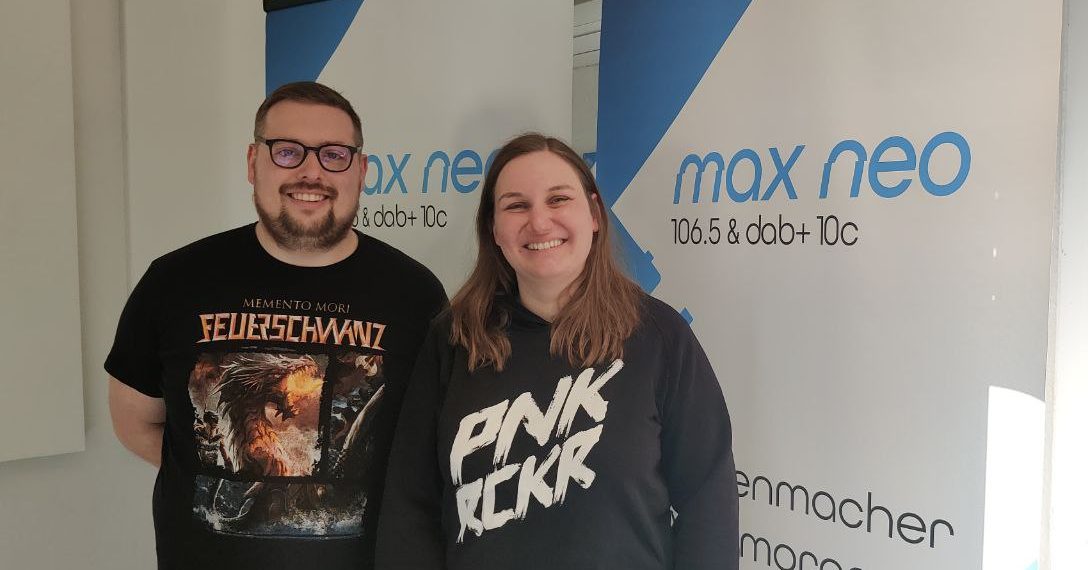 Das Foto zeigt Kevin Pfeifer mit Karin Rabhansl vor dem max neo Banner.