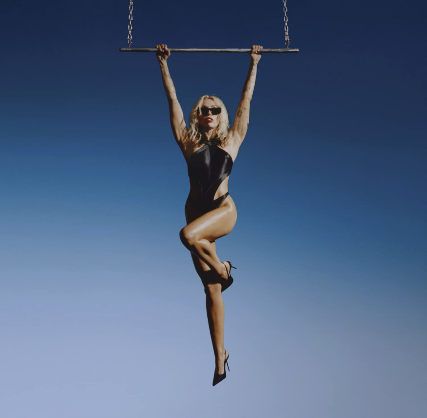 Das Albumcover "Endless Summer Vacation" von Miley Cyrus zeigt die Musikerin, wie sie in einem schwarzen Body an einem Trapez hängt. Der Hintergrund ist blau wie der Himmel.