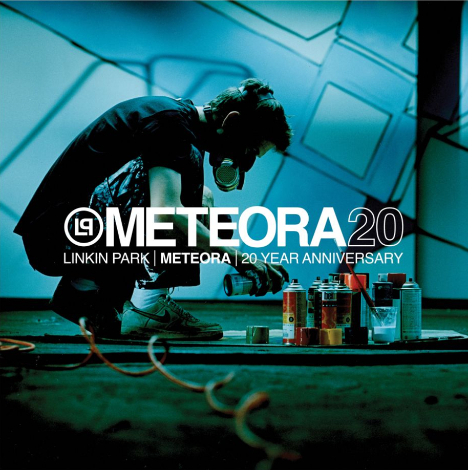 Linkin Park Mitgleid Mike Shinoda sprüht in der Hocke mit einer Spraydose. Rechts vor ihm stehen einige weitere Spraydosen. In der Mitte des Bildes, zwischen Shinoda und den Dosen steht der Titel "Meteora20". Darunter "Linkin Park - Meteora - 20th Anniversary Edition".