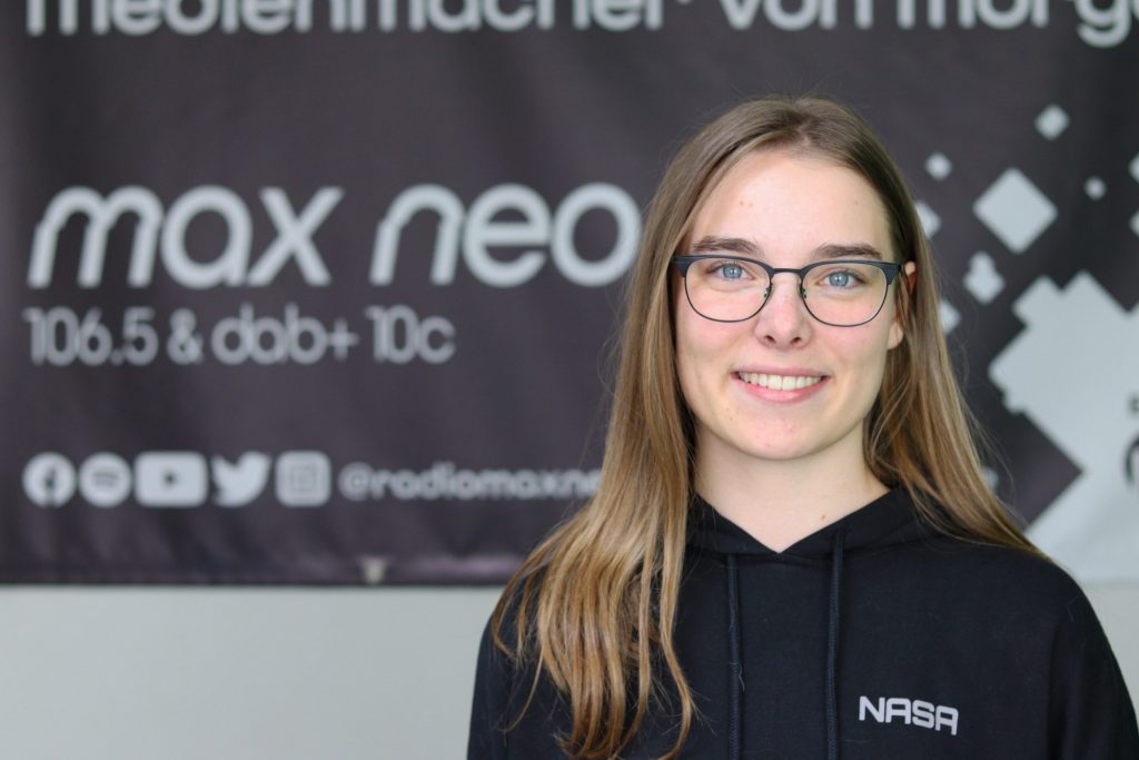 Das Foto zeigt Lea Piasecki im Porträt vor dem max neo Banner.
