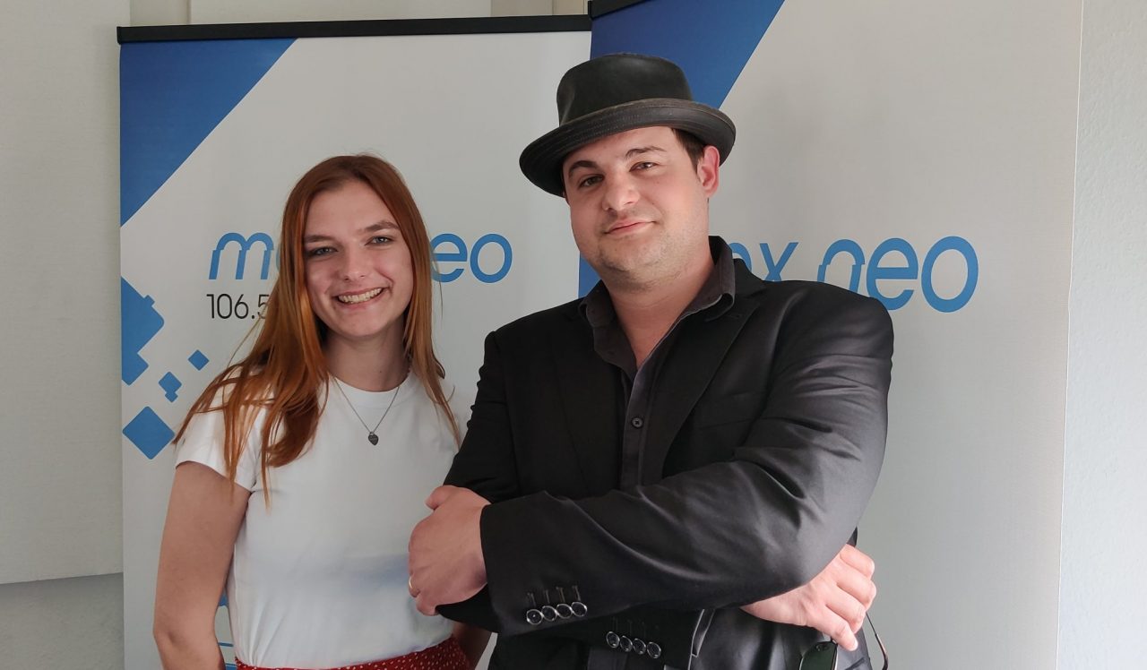 Das Foto zeigt Moderatorin Sophie Rose und Musiker Adrian Kontri alias Klinikel im Porträt. Sie stehen nebeneinander vor einem max neo Banner,