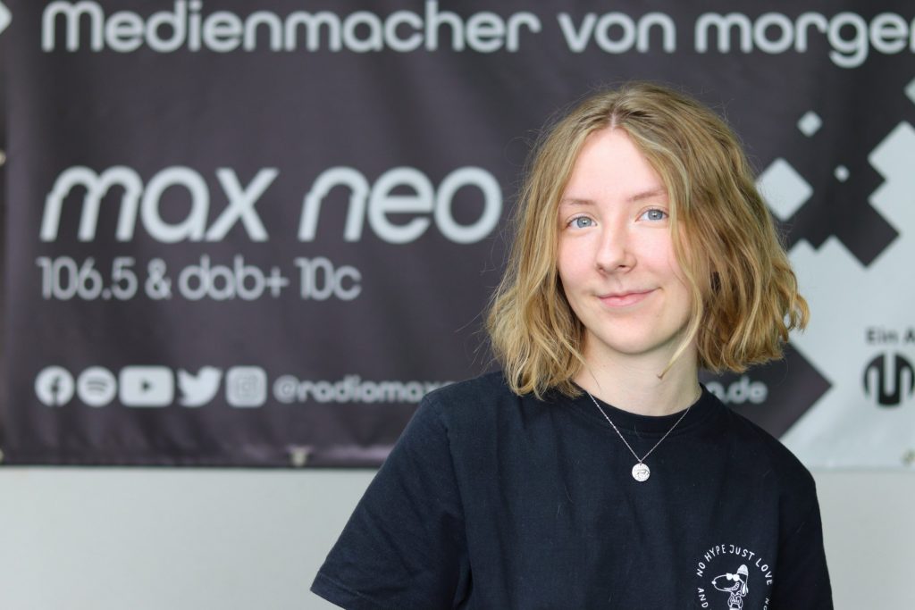 Das Foto zeigt Franziska Muschweck im Porträt vor dem max neo Banner.