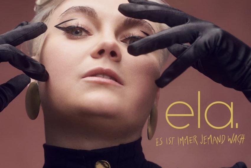 Das Albumcover "Es ist immer jemand wach" von Ela zeigt die Musikerin im Porträt. Sie schaut direkt in die Kamera.