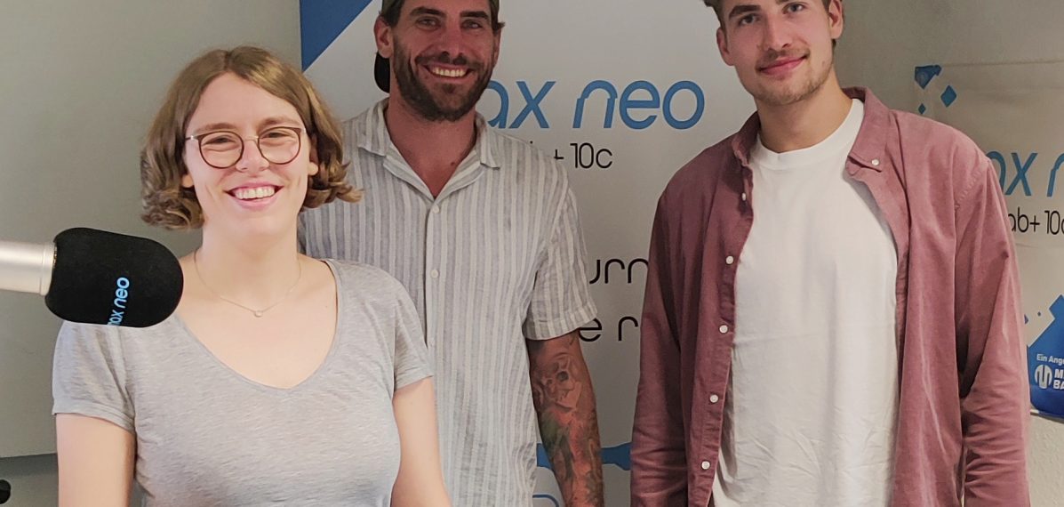 Das Foto zeigt die zwei Ice Tigers-Spieler Constantin Braun und Julius Karrer mit Moderatorin Lena Schnelle.