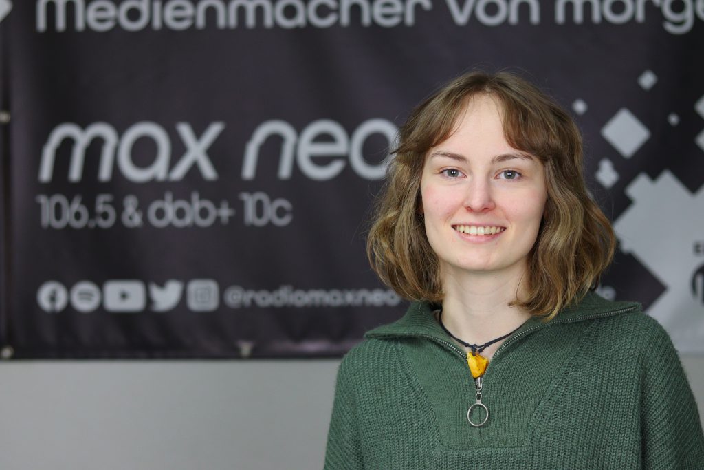 Das Foto zeigt Rahel Behnisch im Porträt vor dem max neo Banner.