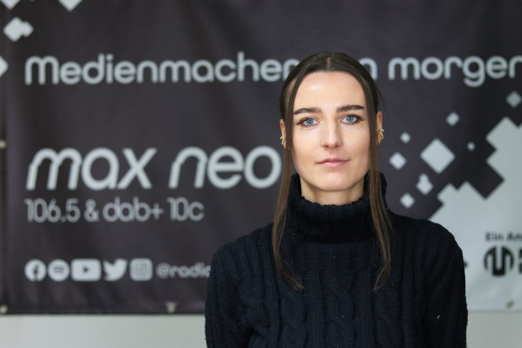 Das Foto zeigt Melanie Bäreis im Porträt vor dem max neo Banner.