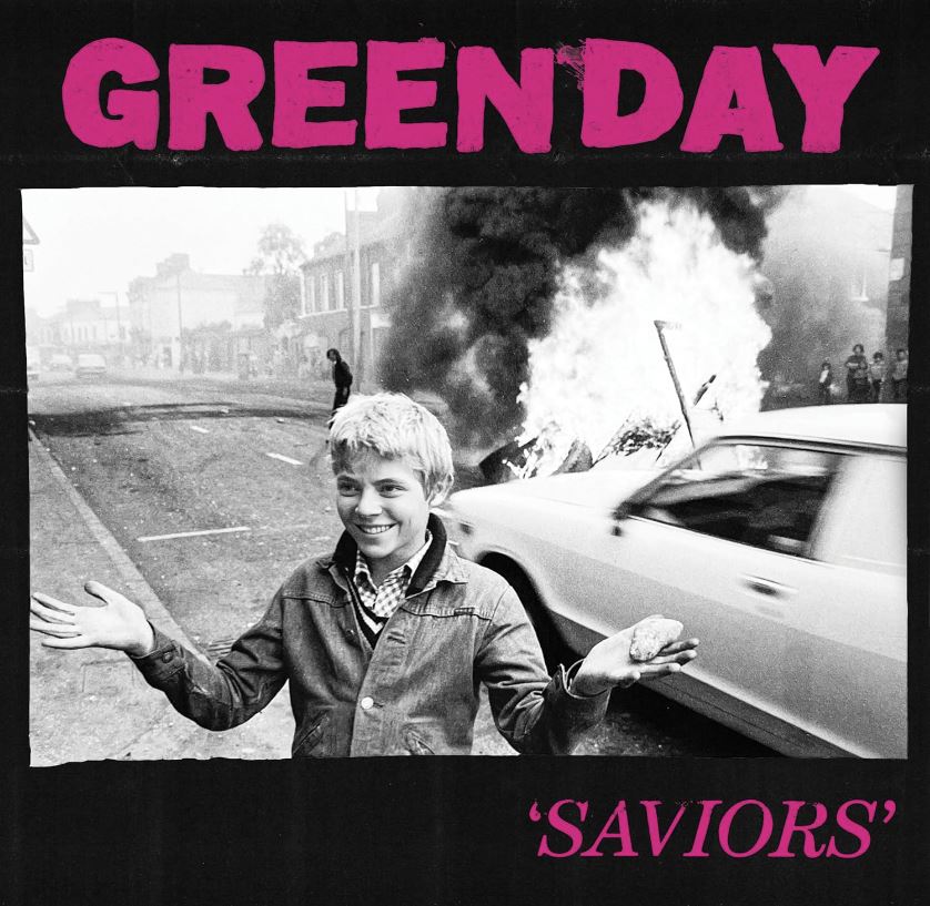 Das Albumcover "Saviors" von Green Day zeigt ein Schwarz-Weiß-Bild von einem Jungen, der auf einer Straße steht. Hinter ihm brennt etwas.