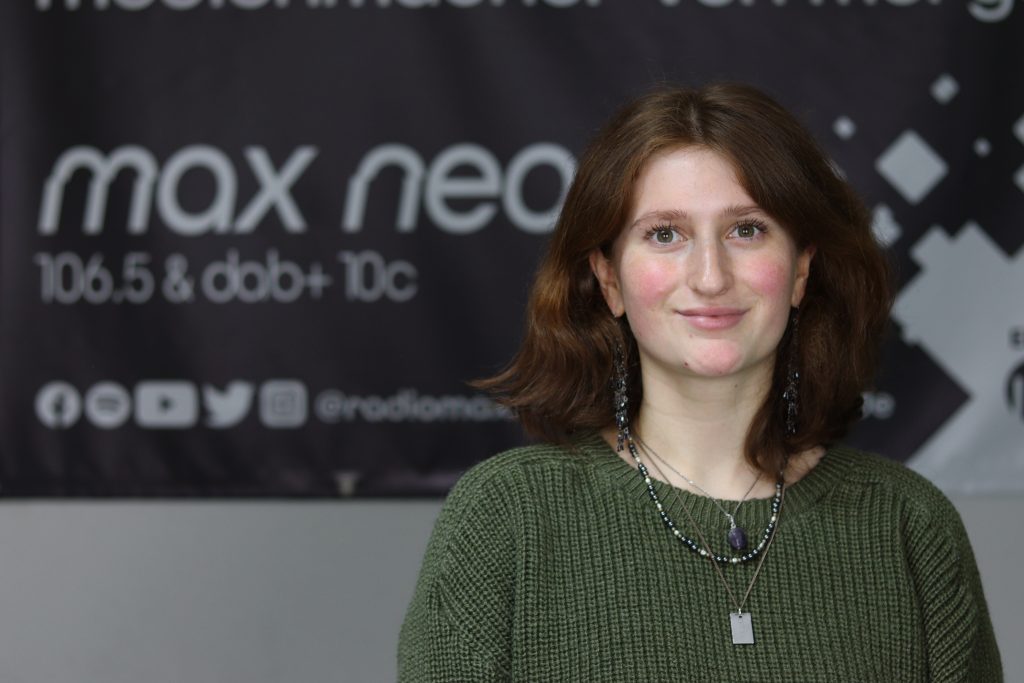 Das Foto zeigt Paula Hofmann im Porträt vor dem max neo Banner.