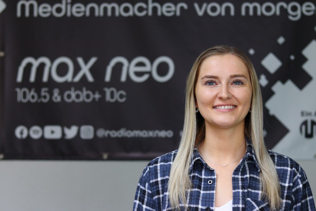 Das Foto zeigt Viola Hartleb im Porträt vor dem max neo Banner.