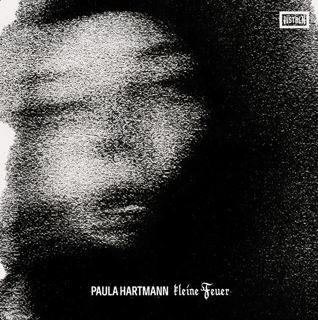 Das Albumcover "Kleine Feuer" von Paula Hartmann zeigt die Musikerin in einer verkörnten Schwez-Weiß-Aufnahme ihres Gesichts.