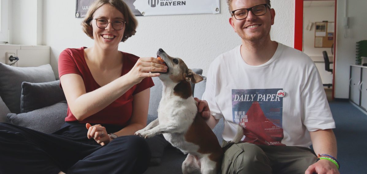 Das Foto zeigt den Musiker Ferdinand Schwartz mit Moderatorin Lena Schnelle und Redaktionshündin Floppy. Die drei sitzen auf dem Sofa.