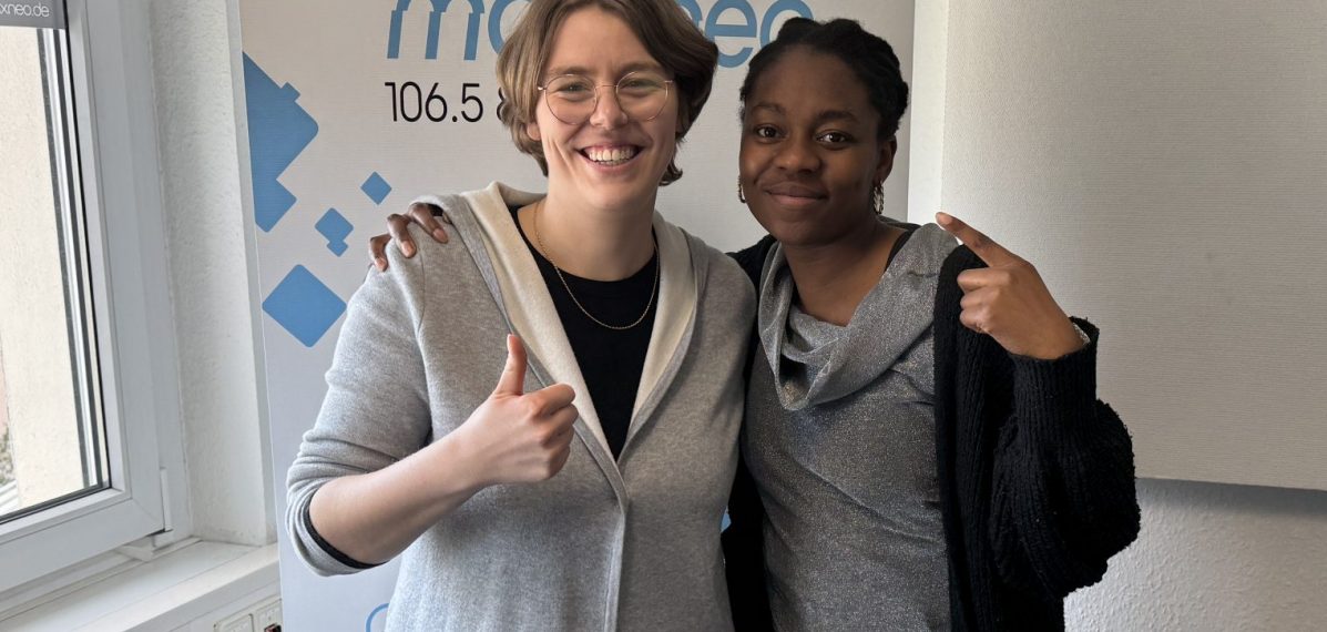 Das Foto zeigt die Moderatorin Lena Schnelle gemeinsam mit der Musikerin Ki'Luanda. Die beiden stehen im max neo Studio.