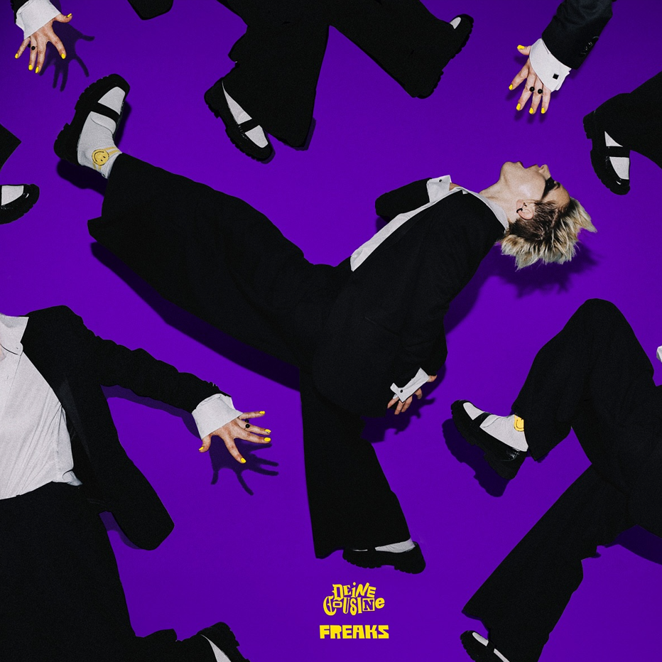 Das Albumcover "Freaks" von Deine Cousine hat einen lila Hintergrund. Im Vordergrund sind mehrere Versionen von Sängerin Ina Bredehorn zu sehen, die unterschiedlich posiert.