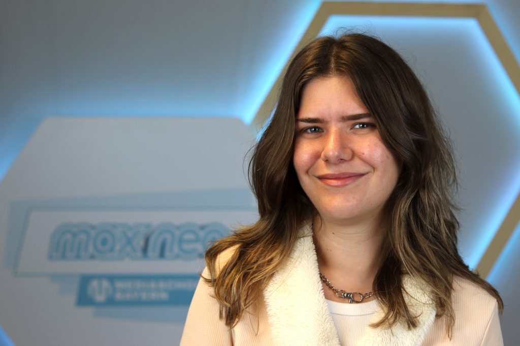 Das Foto zeigt Franziska Zagura im Porträt vor dem max neo Banner.