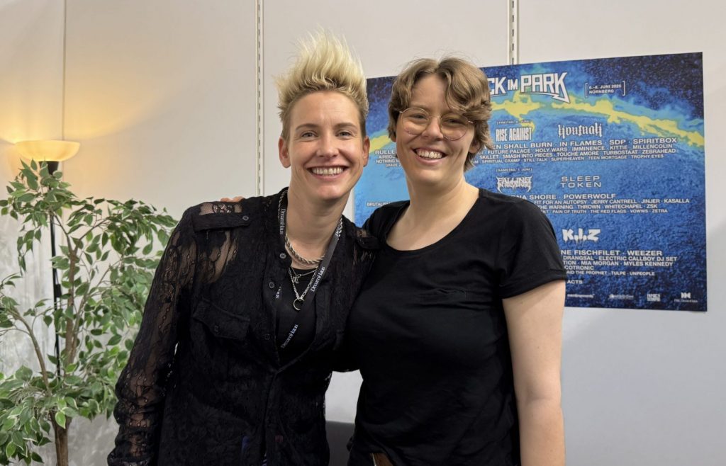Moderatorin Lena steht mit der Musikerin Deine Cousine im Backstagebereich von Rock im Park