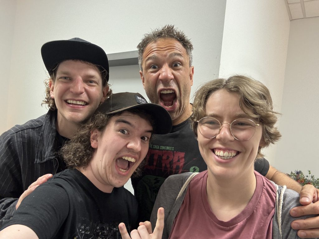 Das Foto ist ein Selfie der Moderator*innen Silas und Lena gemeinsam mit den Musikern Evil Jared x Krogi.
