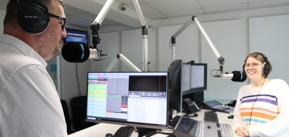 Das Foto zeigt Moderatorin Lena Schnelle im Gespräch mit Kai Maltz-Kummer. Sie stehen in einem Radiostudio.