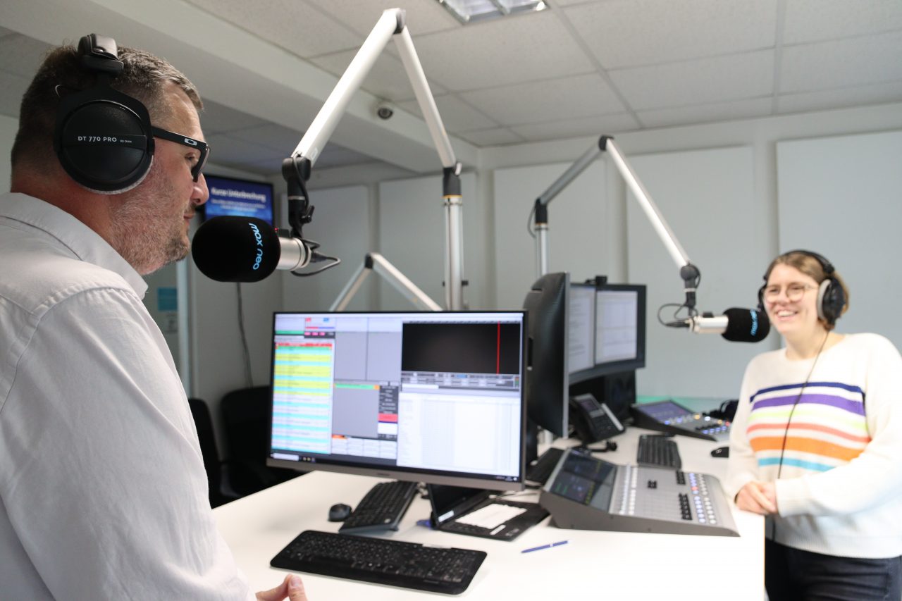 Das Foto zeigt Moderatorin Lena Schnelle im Gespräch mit Kai Maltz-Kummer. Sie stehen in einem Radiostudio.