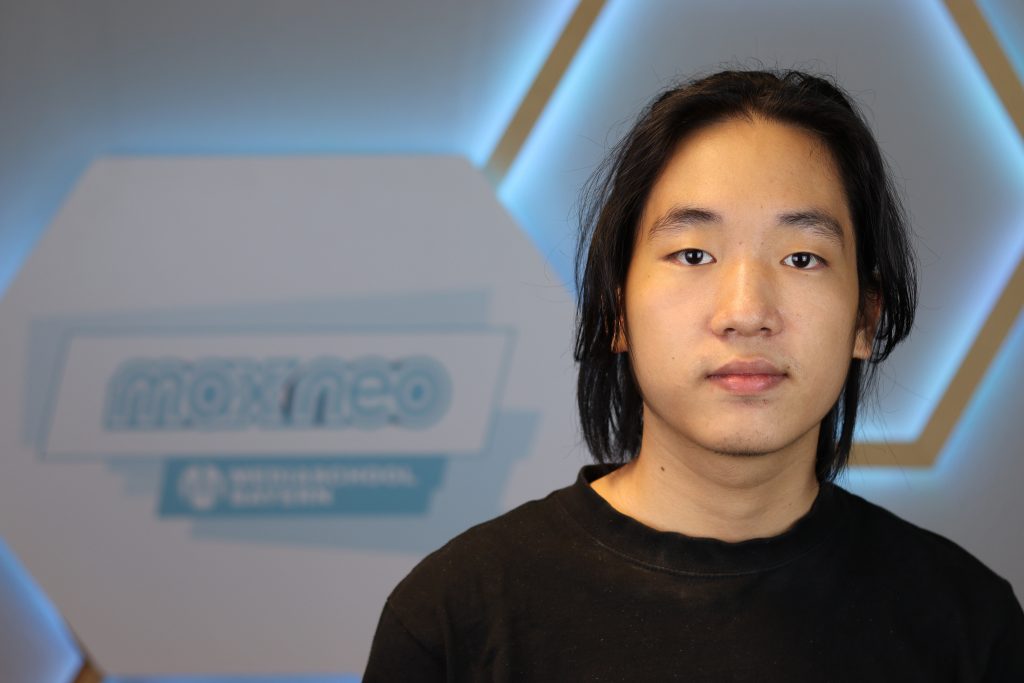 Das Foto zeigt Jacky Dao im Porträt vor dem max neo Logo.