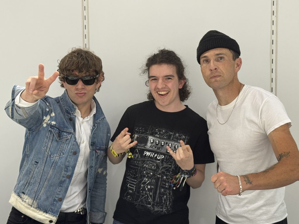 Das Foto zeigt Moderator Silas mit zwei Bandmitgliedern von Spiritual Cramp.
