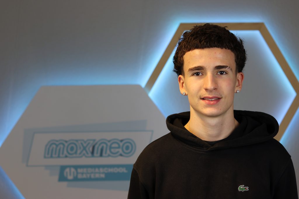 Das Foto zeigt Hannes Neubeck im Porträt vor dem max neo Banner.