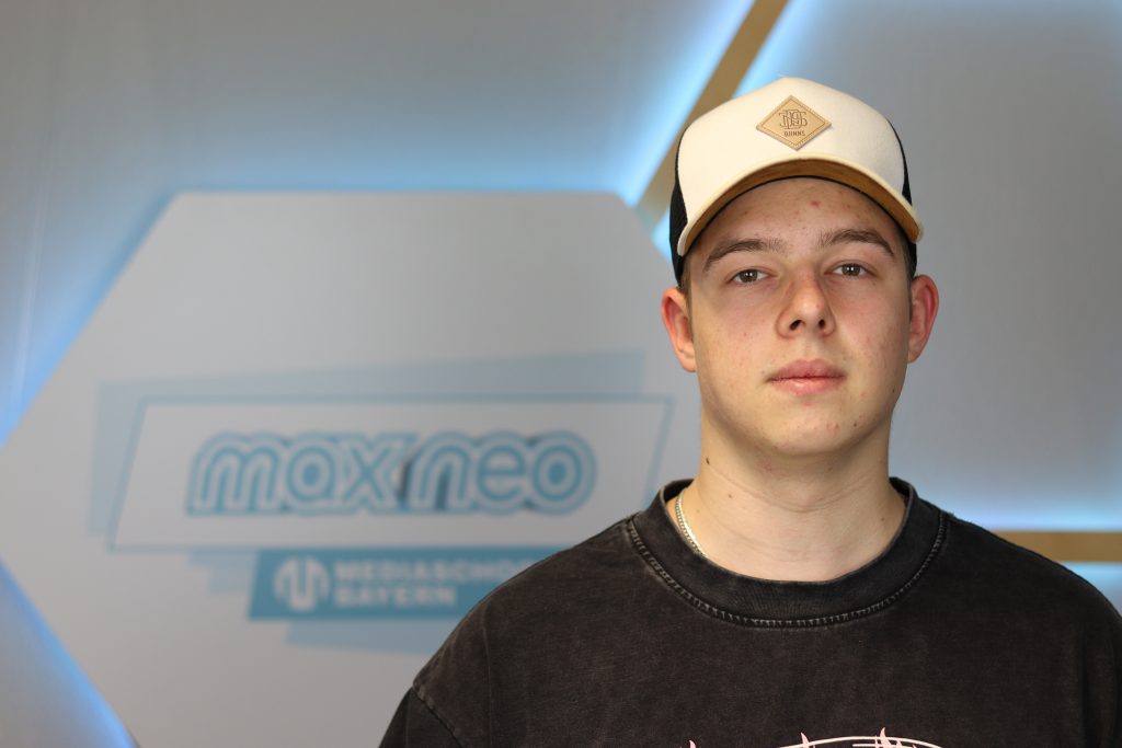 Das Foto zeigt Fabio Noventa im Porträt vor dem max neo Banner.