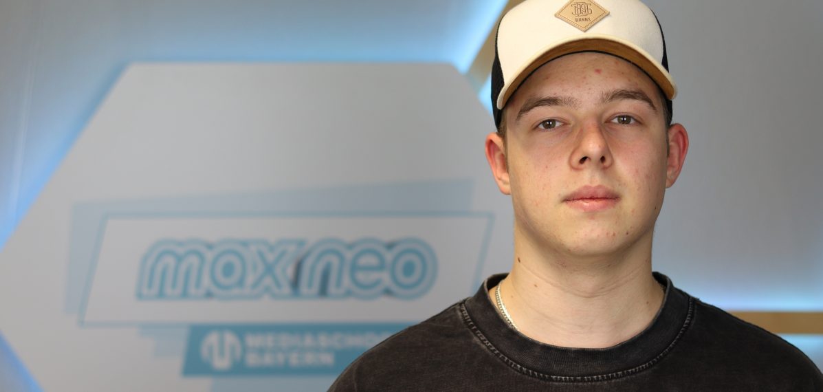 Das Foto zeigt Fabio Noventa im Porträt vor dem max neo Banner.