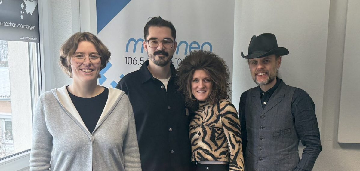 Das Foto zeigt die Moderatorin Lena Schnelle gemeinsam mit der Band Muddy What?.