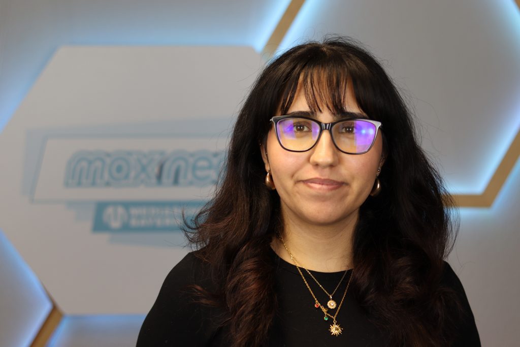 Das Foto zeigt Sidar Yavuz im Porträt vor dem max neo Logo.