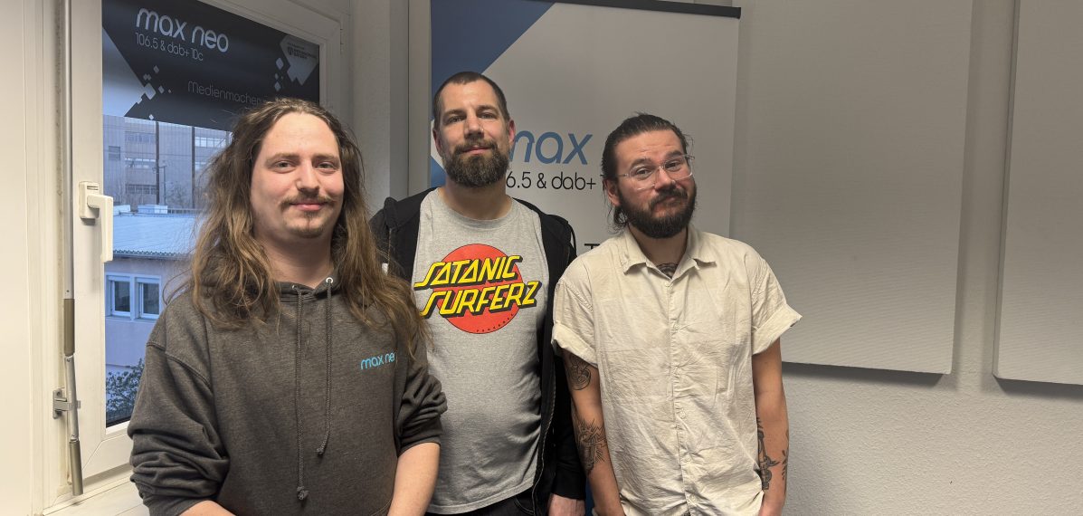 Das Foto zeigt den Moderator Lars Eberhard gemeinsam mit Jens und Basti von der Band Melonball.